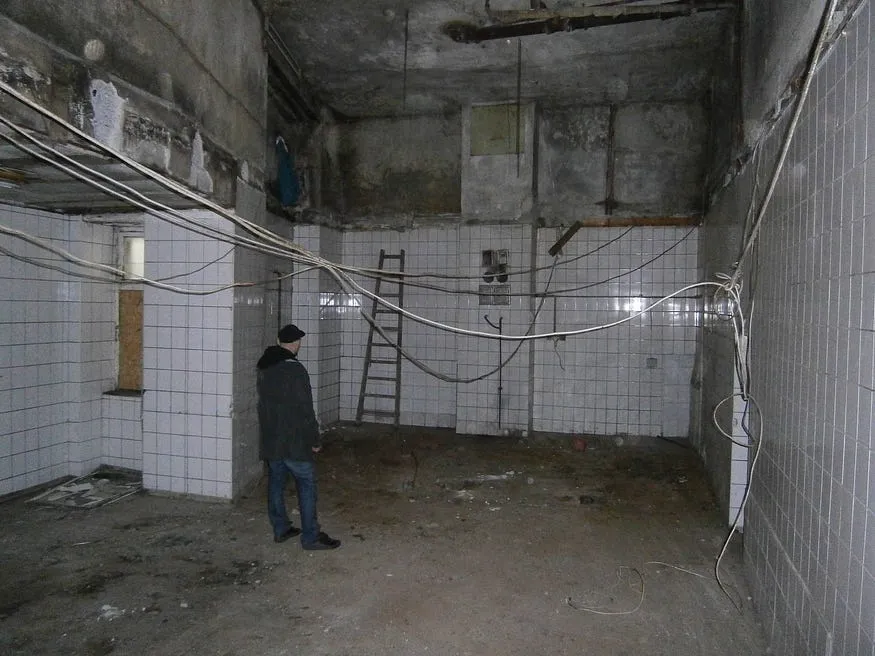 Man standing in a room before renovation.